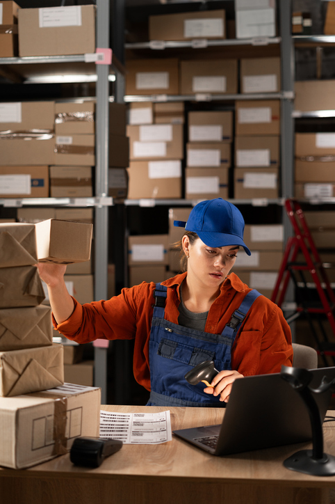 Woman working on computer in warehouse